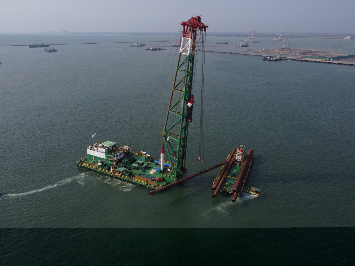 The piling barge SWI Sulawesi X is handling SPP piles delivered by the thruster barge Iso Maju